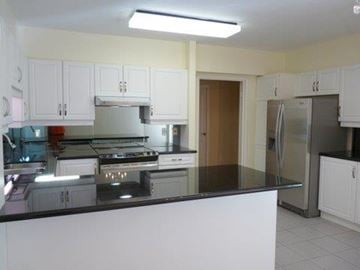 Toronto apartment for rent - A kitchen with white cabinets and a black countertop.