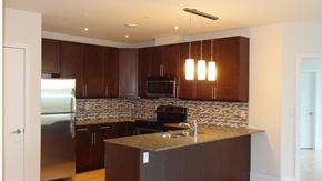 Toronto apartment for rent - A kitchen with brown cabinets and a granite countertop.