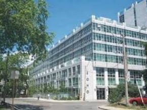 Toronto apartment for rent - A large glass building with trees in front.