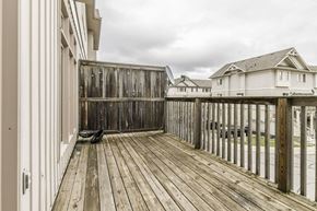 Waterloo apartment for rent - A wooden deck with a bench and a building in the background.