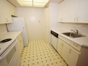 Toronto apartment for rent - A kitchen with white cabinets and a yellow floor.