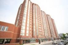 Toronto apartment for rent - A tall red building with many windows is the main focus of the image.