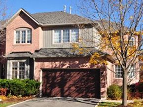 Toronto apartment for rent - A house with a brown garage door and a tree in front.