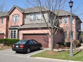 Toronto apartment for rent - A black car is parked in front of a red brick house.