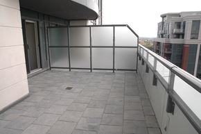 Toronto apartment for rent - A balcony with a glass railing and tiled floor.