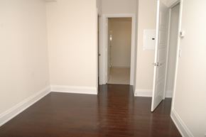 Toronto apartment for rent - A hallway with a wooden floor and two doors.