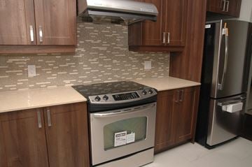Toronto apartment for rent - A kitchen with a stove top oven and a refrigerator.