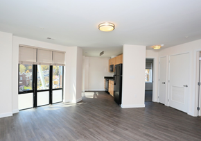 Washington apartment for rent - the living room and kitchen of an apartment with a wood floor and a large window