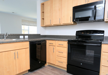 Washington apartment for rent - a kitchen with black appliances and wooden cabinets
