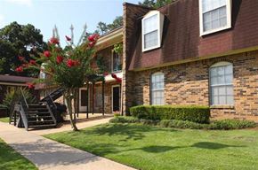 Mobile apartment for rent - a brick house with a tree in the yard