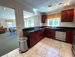 Manchester apartment for rent - A kitchen with red cabinets and a stainless steel dishwasher.