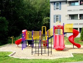 Manchester apartment for rent - A playground with a red slide and a yellow and purple play structure.