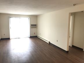 Milford apartment for rent - an empty living room with wood floors and a window
