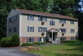 Merrimack apartment for rent - a large yellow house with blue shutters and a driveway