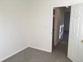 Manchester apartment for rent - an empty bedroom with white walls and a door to a hallway
