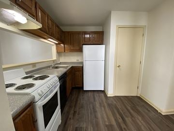 Manchester apartment for rent - A kitchen with a white stove top oven and a white refrigerator.