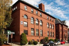 Manchester apartment for rent - a large brick building with cars parked in front of it