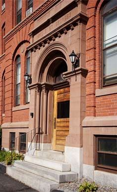 Manchester apartment for rent - a red brick building with a wooden door and stairs