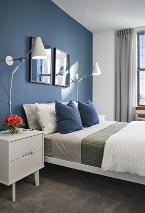 Hoboken apartment for rent - a blue and white bedroom with a bed and lamps