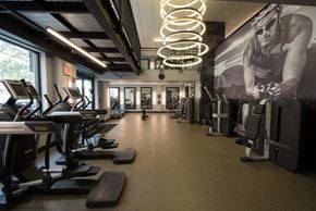 Hoboken apartment for rent - the gym has cardio equipment and a large wall mural of a man working out on