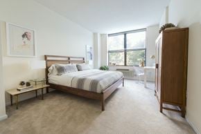 Hoboken apartment for rent - a bedroom with a bed and a dresser and a window