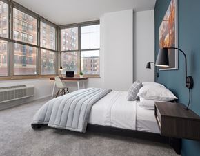 Hoboken apartment for rent - a bedroom with a bed and a desk with a window