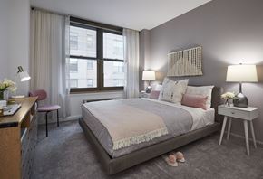 Hoboken apartment for rent - a bedroom with a bed and a desk and a window