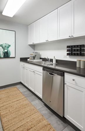 Jersey City apartment for rent - a kitchen with white cabinets and a stainless steel dishwasher