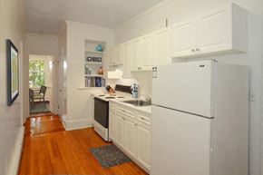 Brookline apartment for rent - a kitchen with white cabinets and a refrigerator