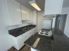Los Angeles apartment for rent - an empty kitchen with granite counter tops and white cabinets