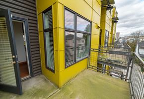 Seattle apartment for rent - a balcony with a yellow building on it