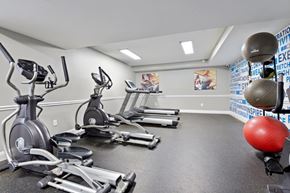 Baltimore apartment for rent - A gym with a row of treadmills, elliptical machines, and a red exercise ball.