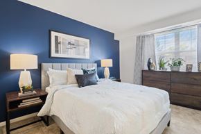 Baltimore apartment for rent - a bedroom with a large bed and a blue accent wall