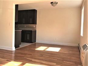 Garnerville apartment for rent - an empty living room with wooden floors and a kitchen