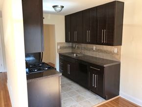 Garnerville apartment for rent - an empty kitchen with black cabinets and a sink