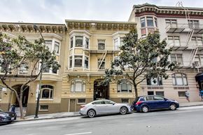 San Francisco apartment for rent - A silver car is parked on the side of the street in front of a building.