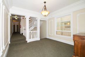 San Francisco apartment for rent - A hallway with a staircase and a chandelier.