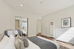 Brentwood apartment for rent - A bedroom with a large bed and a mirror on the wall.