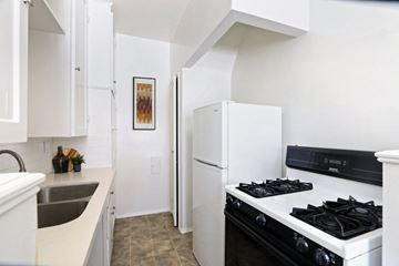 Beverly Hills apartment for rent - A kitchen with a black stove top oven and a white refrigerator.