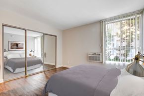 Encino apartment for rent - A bedroom with a large bed and a mirrored closet door.