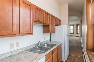 Devils Lake apartment for rent - a kitchen with wood cabinets and a sink and a refrigerator