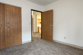 Devils Lake apartment for rent - a bedroom with two doors and a hallway to a bathroom