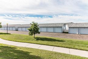 Bismarck apartment for rent - a row of white garages with a sidewalk and grass