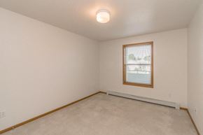 Bismarck apartment for rent - the living room of an empty home with a window and white walls