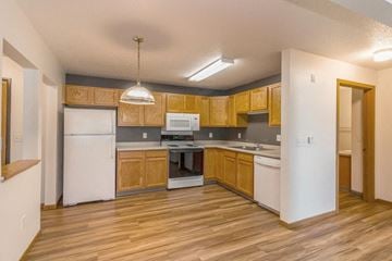Bismarck apartment for rent - a kitchen with wooden cabinets and white appliances
