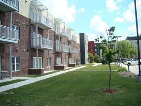 Grand Forks apartment for rent - a row of brick apartment buildings with green grass and a sidewalk