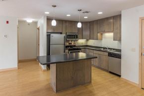 Grand Forks apartment for rent - a large kitchen with stainless steel appliances and a black counter top