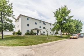 Grafton apartment for rent - the exterior of a white apartment building with cars parked in front
