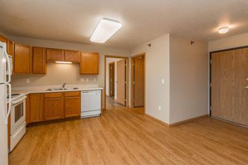Grafton apartment for rent - an empty kitchen with wooden floors and white appliances