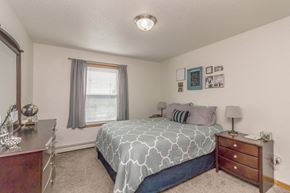 Bismarck apartment for rent - a bedroom with a bed and a dresser and a window